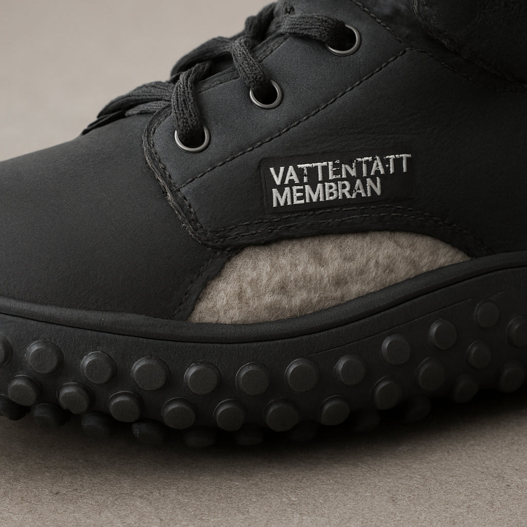 En närbild av en vinterbarfotasko med tydlig dubbdotsul, vattentätt membran synligt och en tjock, varm ullsula. Alt: jämförelsetabell för bästa barfotaskor för vintervandring, fokus på tekniska specifikationer.